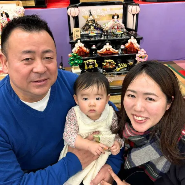 雛人形の前で記念撮影する赤ちゃんと両親